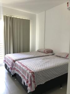 伊塔齐米林Village Areias de Itacimirim的一间卧室配有一张带红白毯子的床