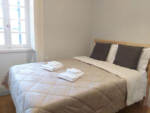 波尔图Queen's Garden Hostel的一间卧室配有一张大床和毛巾
