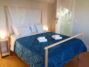 波尔图Queen's Garden Hostel的一间卧室配有一张大床和毛巾