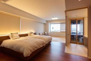 云仙市Iseya, Seaview Private Onsen Bath的一张大床,位于带大窗户的房间里