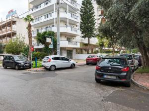 雅典Homely Apartment in Piraeus with Balcony的停车场,停车场停在大楼前