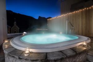 圣卡夏诺Hotel La Fradora - Dolomites Hotel的一个带喷泉的按摩浴缸
