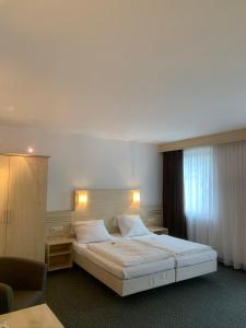 美因河畔法兰克福Hotel Mondial Comfort - Frankfurt City Centre的一间卧室设有一张大床和一个窗户。