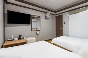 首尔柯姆康汽车旅馆的一间卧室配有两张床和一台平面电视