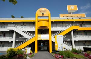 蒙德维尔东卡昂 - 蒙德维尔普瑞米尔经典酒店的前面有黄色标志的大建筑