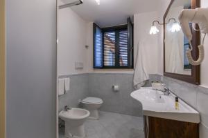 梅塔Flowers apartments & rooms的一间带水槽、卫生间和镜子的浴室