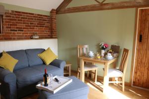 灵伍德Blashford Manor Farmhouse - The Shetland Cottage的客厅配有蓝色的沙发和桌子