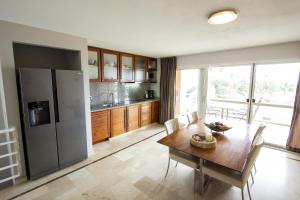 克拉伦代克Seaside Apartment Turtle的厨房配有木桌和冰箱。