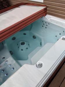 KingsclearStrong Timbers BnB的木制甲板上的按摩浴缸