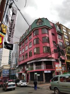 拉巴斯Downtown Hotel的街道拐角处的粉红色建筑