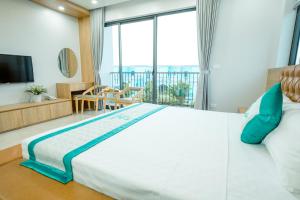 富国Green Tree Hotel Phú Quốc的一间卧室设有一张大床和大窗户