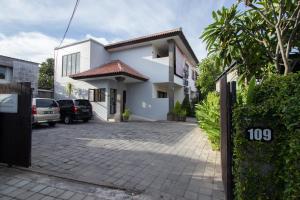 沙努尔巴厘岛天堂公寓 的白色的房子,前面有停车位