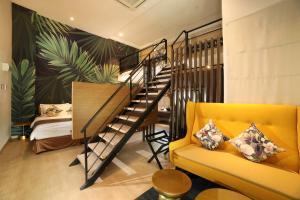 怡保Sojourn Spa Hotel Ipoh的客厅设有楼梯和黄色沙发
