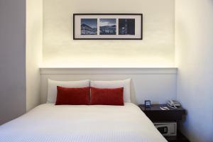 台中市宝岛53行馆的卧室配有带红色枕头的白色床