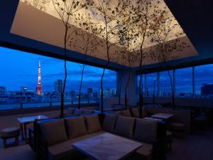 东京Mitsui Garden Hotel Roppongi Tokyo Premier的一间配有沙发的客房,享有艾菲尔铁塔的景色