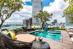 胡志明市Silverland Jolie Hotel的一个带游泳池的屋顶庭院,享有城市美景