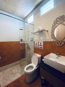 沙努尔聚隆招待所的浴室配有卫生间、淋浴和盥洗盆。