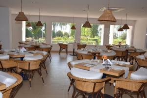 ShādipurPeerless Resort Port Blair的餐厅设有桌椅和窗户。