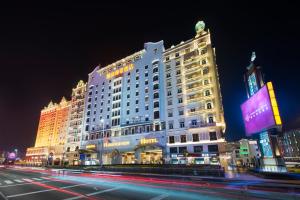 澳门澳门励庭海景酒店的一座大型酒店大楼,晚上有街道