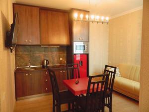 第比利斯爱丽恩精品酒店的厨房配有桌椅和红色冰箱。