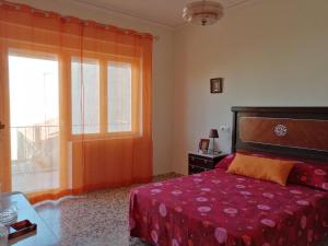 TobarraAlojamiento Rural的一间卧室设有红色的床和窗户。