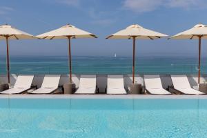帕尔马海滩艾龙公园HM酒店的一个带椅子和遮阳伞的游泳池