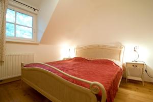 博恩Ferienhaus Zander mit Sauna的一间卧室配有一张带红色毯子的床和窗户。