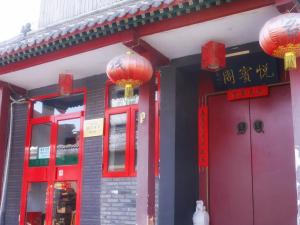 北京Beijing Yue Bin Ge Courtyard Hotel的红色门和红色灯笼的建筑
