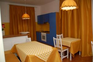 西维尔诺瓦·马尔凯B&B Milù的厨房配有蓝色橱柜和桌椅