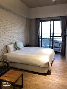 垦丁大街HIDO旅店的一间卧室设有一张大床和一个大窗户