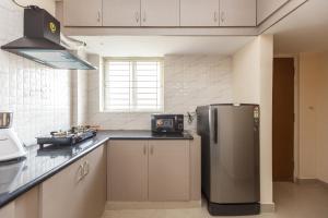 班加罗尔Misty Meridian Serviced Apartments的厨房配有不锈钢冰箱和窗户