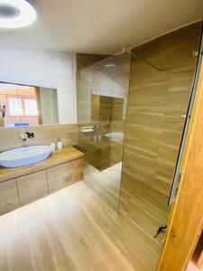 弗拉绍AlpinLodge Flachau的一间带玻璃淋浴和水槽的浴室