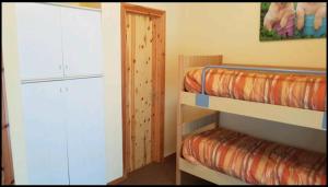 阿贝托内trilocale sulle piste da sci的客房设有两张双层床和衣柜。