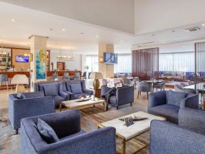 坎帕拉Golden Tulip Canaan Kampala的大型客厅配有蓝色的椅子和桌子