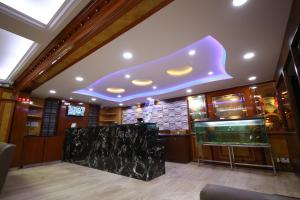 班加罗尔Hotel Chetan International的餐厅设有鱼缸和紫色天花板