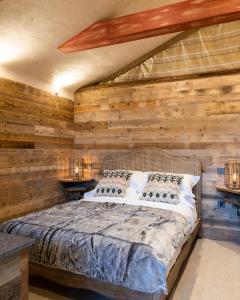 LangleyThe Potting Shed Maidstone的卧室配有木墙内的一张床