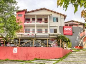 ParipeOYO Praia Hotel Recanto do Tomé - Salvador的前面有红墙的建筑