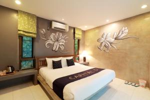 湄林Capital O 464 At Nata Chiangmai Chic Jungle的卧室配有一张墙上鲜花的大床