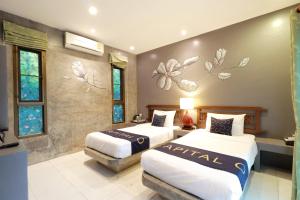 湄林Capital O 464 At Nata Chiangmai Chic Jungle的酒店客房,设有两张床,墙上挂着鲜花。