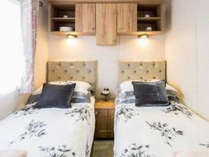 阿维莫尔Cairn View Chalet的两张睡床彼此相邻,位于一个房间里