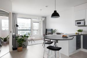 赫尔辛基SleepWell Apartment Rio with private sauna and parking的厨房以及带桌椅的起居室。
