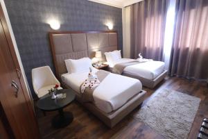 拉巴特海尔南谢尔酒店的酒店客房设有两张床和一张桌子。