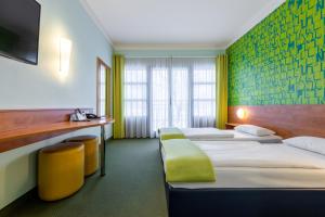 佩格尼茨Hotel Fränkische Schweiz-Pegnitz的酒店客房设有三张床和一张书桌