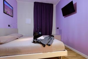 卡利亚里Millefiori的一间卧室配有一张紫色墙壁的床