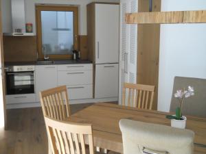 Sankt Veit in DefereggenBergappartement Talblick的厨房配有木制餐桌和椅子