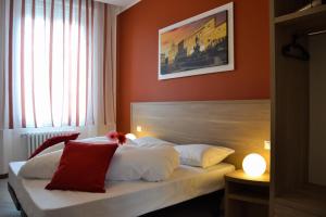 博洛尼亚Palazzo Liberty BnB的一间卧室配有带白色和红色枕头的床