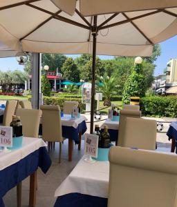 比比翁阿迪亚提克酒店的一间带桌椅和遮阳伞的餐厅