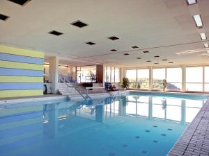 洛伊费尔芬根拉姆萨奇巴德酒店的一座大型游泳池,位于一座带窗户的建筑内