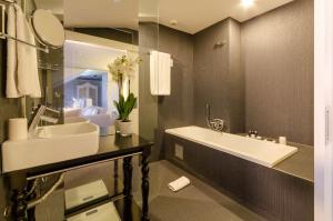 里斯本豪华精品酒店的浴室配有大型白色水槽和浴缸。