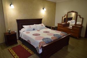 基多卡萨莫特瑞酒店的一间卧室配有一张床、梳妆台和镜子